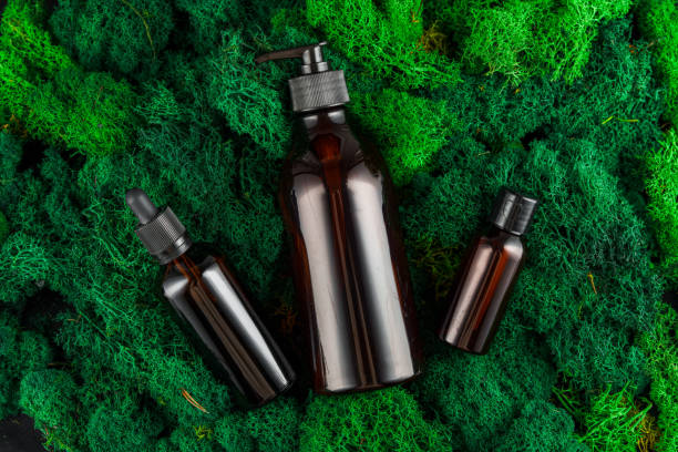 istock Brown glass dropper bottles arranged on green moss in a natural setting 2171102940
