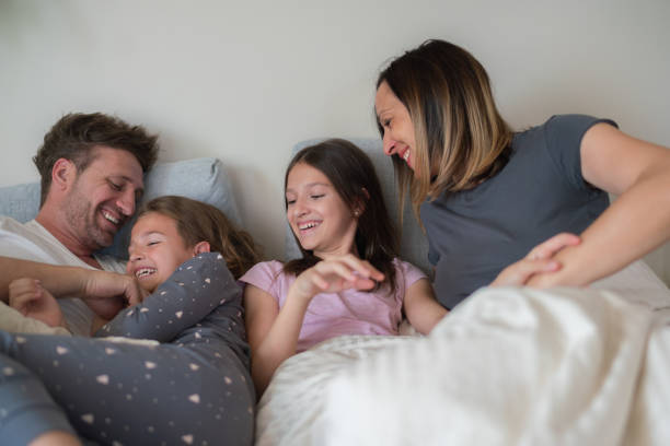istock Parents tickle their children in bed 2171104078