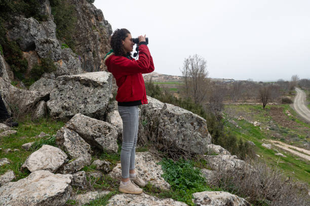 istock A young girl observing in nature with binoculars. 2171105207