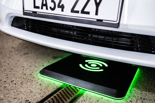 istock Wireless charging pod under a car in front of the house at night 2171105357