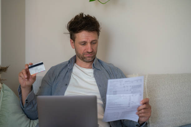 istock Man pays bills with credit card via laptop 2171106882