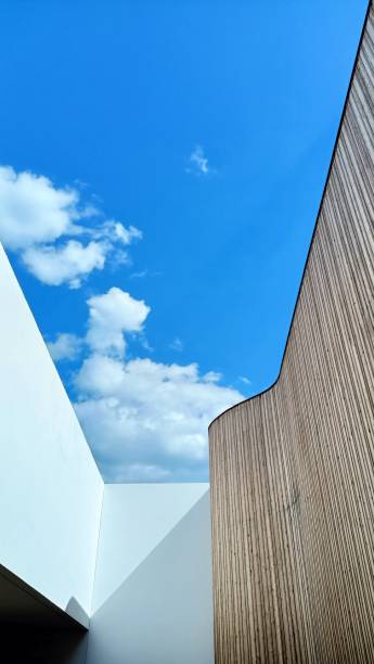 istock A tall building stands against a vibrant blue sky filled with clouds behind it 2171107804