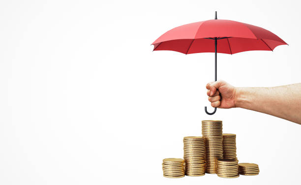istock Hand holding red umbrella over stack of golden coins on white background. 2171107903