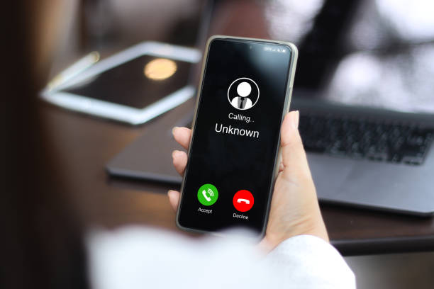 istock Unknown number displayed showing on smart mobile phone. Human use smartphone with incoming call from unknown number, spam, hacker, call center, crime, 2171110496
