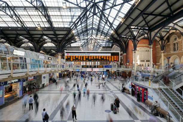 London, UK 08 27 2024 Long exposure of the bustling concourse at London Liverpool Street Station with the large timetable departure board raised above.