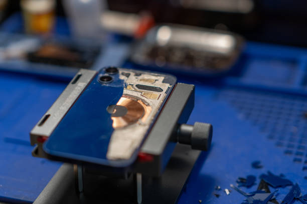 istock Repairing Smartphone Back Glass, The image shows a technician working on a phone 2171120181