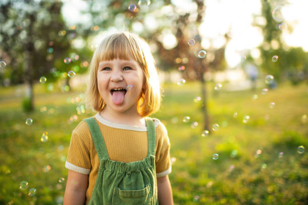 istock Little girl playing  in a park with soap bubbles 2171120239