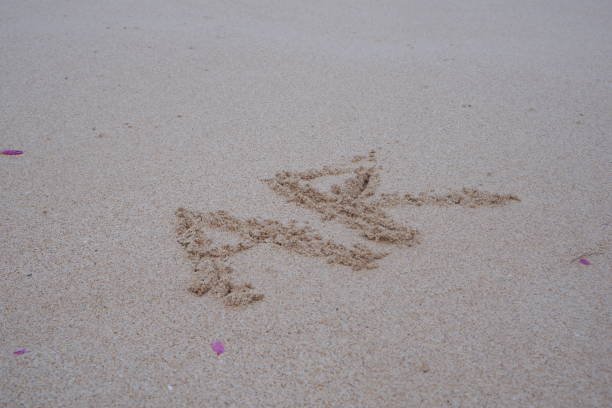 Beach sand with alphabet initials A and R.