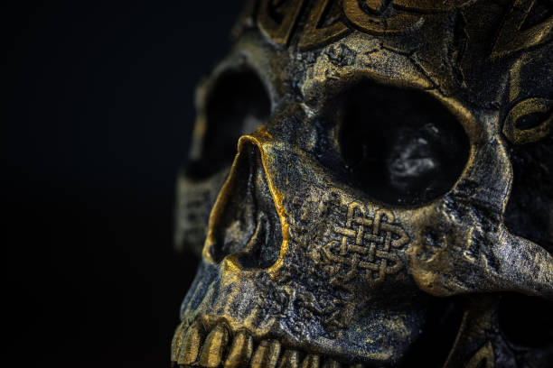 The skull is a symbol with deep roots in esoteric practices, representing mortality and transformation. In some cultures, it is believed to have protective powers or be used in rituals. Dark metallic and golden colours