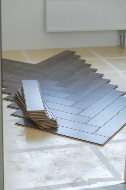 istock Worker installing laminate flooring in an apartment, carefully aligning wooden 2171129180