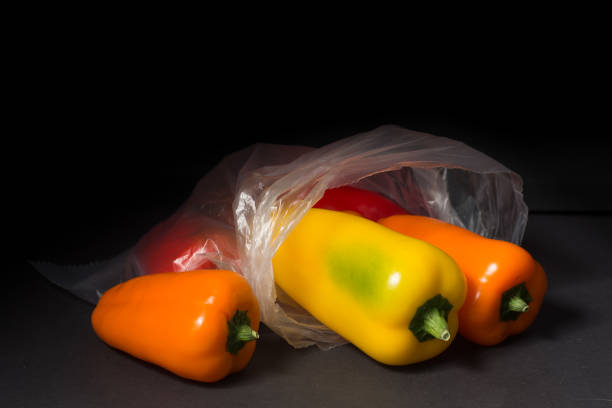 still life of Peppers in a plastic bag on a black background. Copy space.