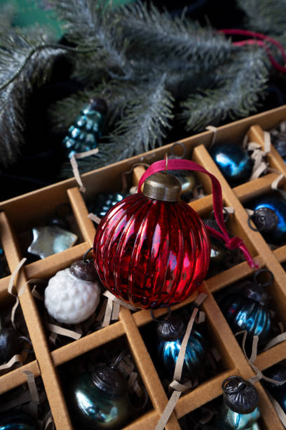 istock A box with vintage Christmas ornaments is showcased on a silver fabric backdrop, creating a festive display 2171130448