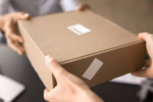 istock Female hands handing over sealed cardboard box to customer 2171130785