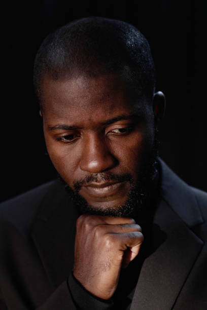 istock Portrait of Sorrowful Black Man on Dark Background in Studio 2171130830