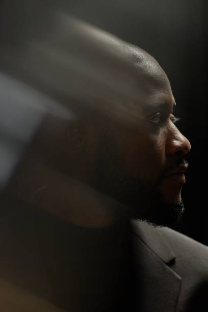 istock Side Portrait of Black Man Looking away in Low Key Studio 2171130841