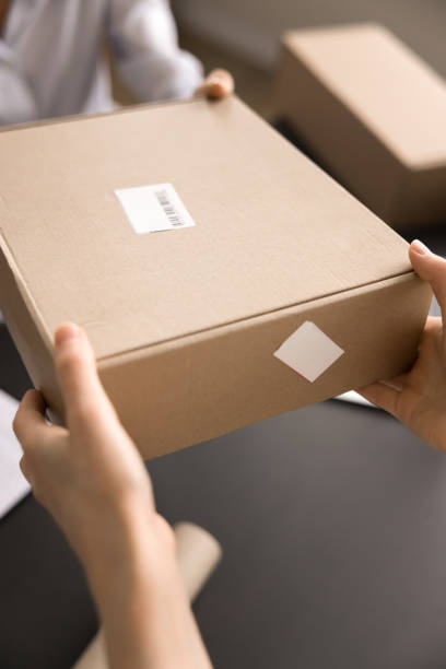 istock Client takes parcel box in postal services, closeup cropped shot 2171130992