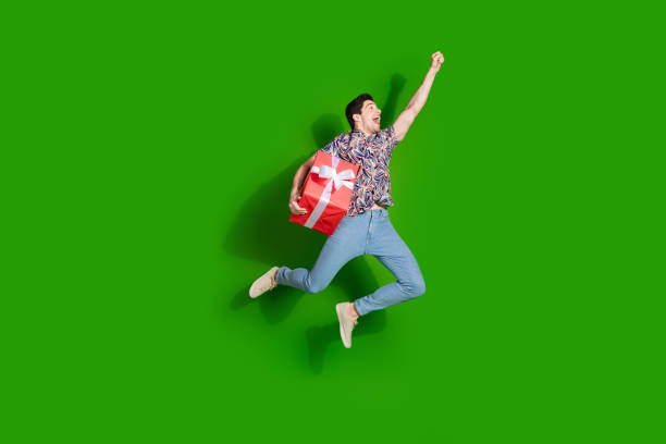 istock Full size photo of overjoyed guy dressed print shirt jeans look  empty space hold present box in arm isolated on green color background 2171135196