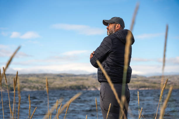 istock A man in down jacket stands alone at the Barents sea coastline 2171136585