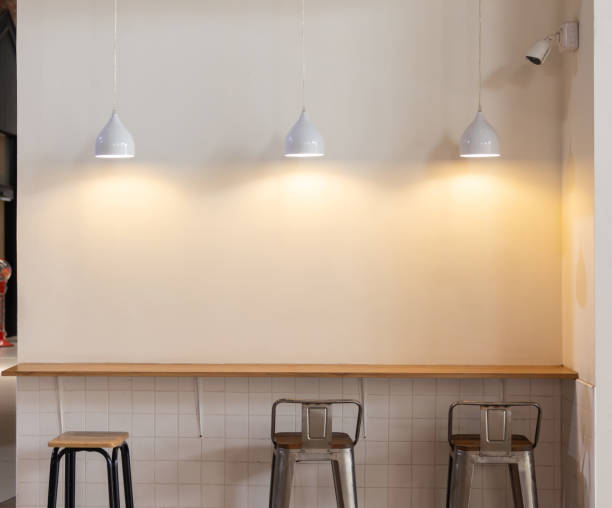 istock A white wall with three hanging lights and three metal chairs 2171142466