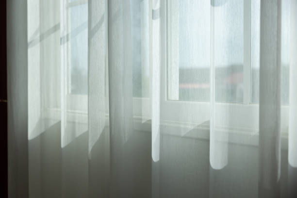istock A window with white curtains is letting in sunlight 2171142564
