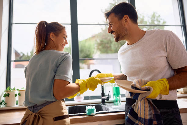 istock Young happy couple doing the dishes in the kitchen. 2171142872