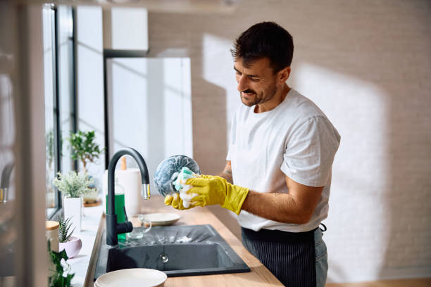 istock Smiling man washing dishes in the kitchen. 2171142938