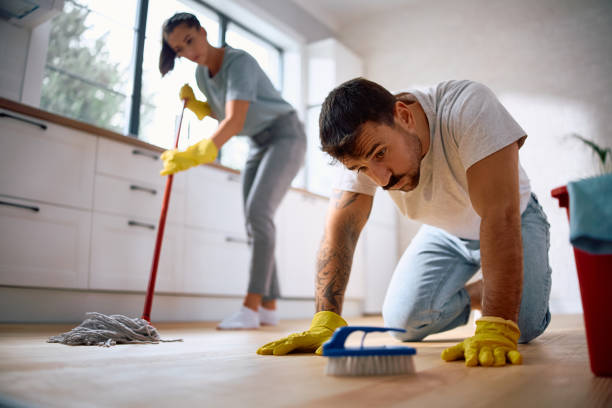 istock Exhausted man cleaning parquet floor with a brush in the kitchen. 2171143312