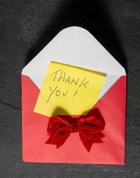 istock Yellow Thank You Post-it Note on a red envelope and red bow on a slate background 2171146622