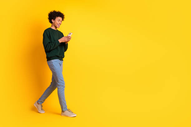 istock Full size photo of nice young man walk use phone wear pullover isolated on yellow color background 2171146830