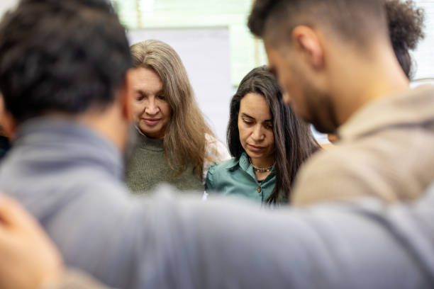 istock Diverse group huddling together in circle for support at community center 2171148875