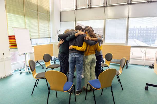 istock Support group standing in a huddle during therapy session in community center 2171148928
