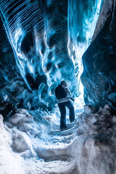 A person is walking through a cave with blue walls