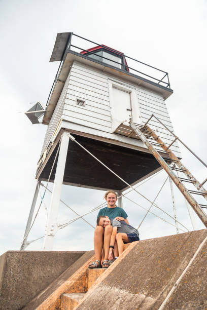 istock Kids Sitting Near Two Harbors, Minnesota Lighthouse 2171161851