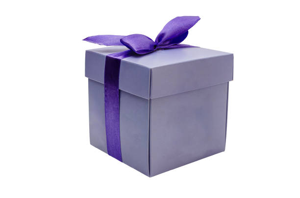 Close-up of a lavender coloured square gift box elegantly wrapped with a deep purple satin ribbon, tied at the top in a bow.