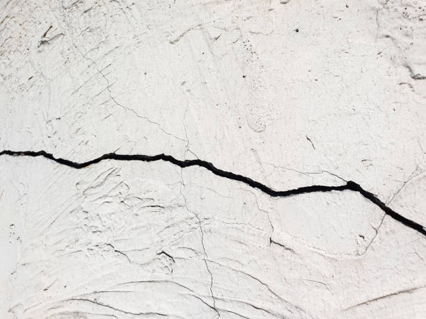 istock Cracks on cement, plastered surface, wall. Cracked plaster, concrete wall, close-up 2171163897