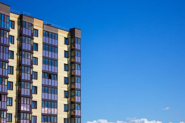 Brick apartment building with space for copy,paste text against sky background. Modern real estate. Apartment, ownership, rentals. Brick apartment building in the city.