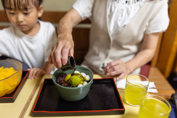 Grandmother pouring syrup on Japanese sweets