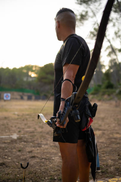 istock A man is holding a bow and arrow in a field 2171171192