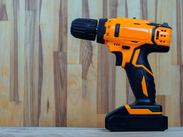 A screwdriver-drill against a wood background, ready for work, is ideal for repairs and construction in the country or at home.