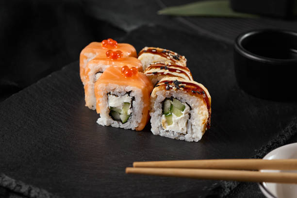 istock Gourmet Salmon and Eel Sushi Roll on Slate Plate with Minimalist Background 2171178130