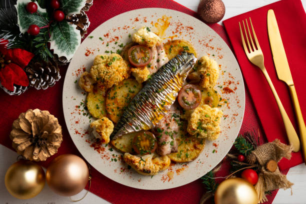 istock Baked mackerel with braised cauliflower and cherry tomatoes. Top view table with christmas decorations. 2171183443