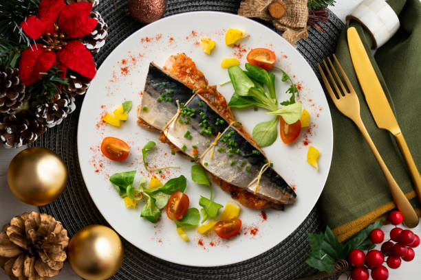 istock Baked mackerel stuffed with vegetables and tomato. Top view table with christmas decoration. 2171184204