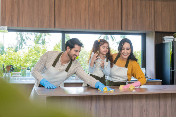 istock A father cleaning a kitchen table alongside his wife while their young daughter standing between them observing the cleaning representing happiness, bonding, and the importance of routine and mental wellbeing. 2171190796