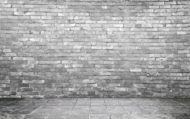 istock grey concrete perspective room for advertising. stamp concrete floor in grid pattern with rustic grey brick wall background. 2171194087