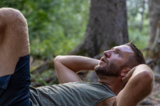 istock Man doing ab crunches on outdoor bench in forest 2171195269