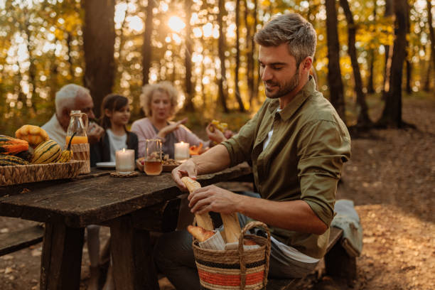 istock Father is breaking bread for his family during a picnic 2171195732