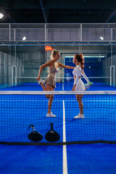 istock Two female padel players helping each other stretch 2171195742