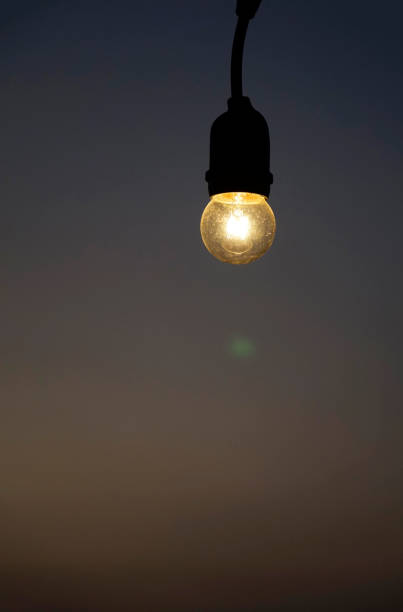 Bright vintage light bulb in background of gradient sunset sky