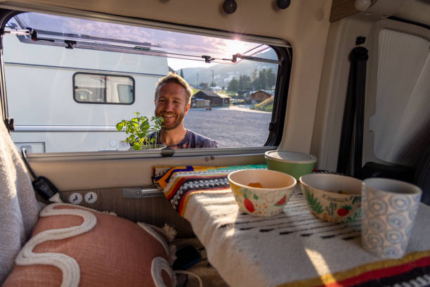 istock Man placing houseplant inside a cozy camper van 2171200560