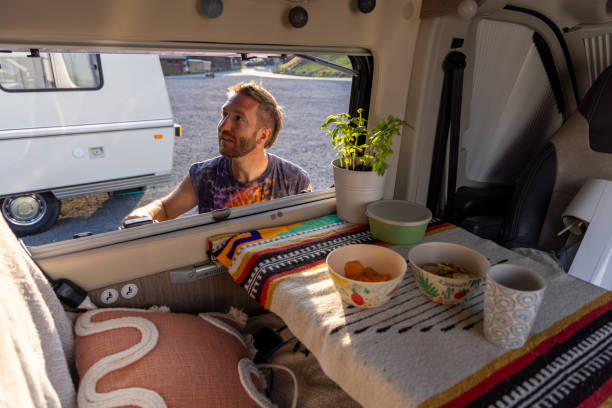 istock Man placing houseplant inside a cozy camper van 2171200589